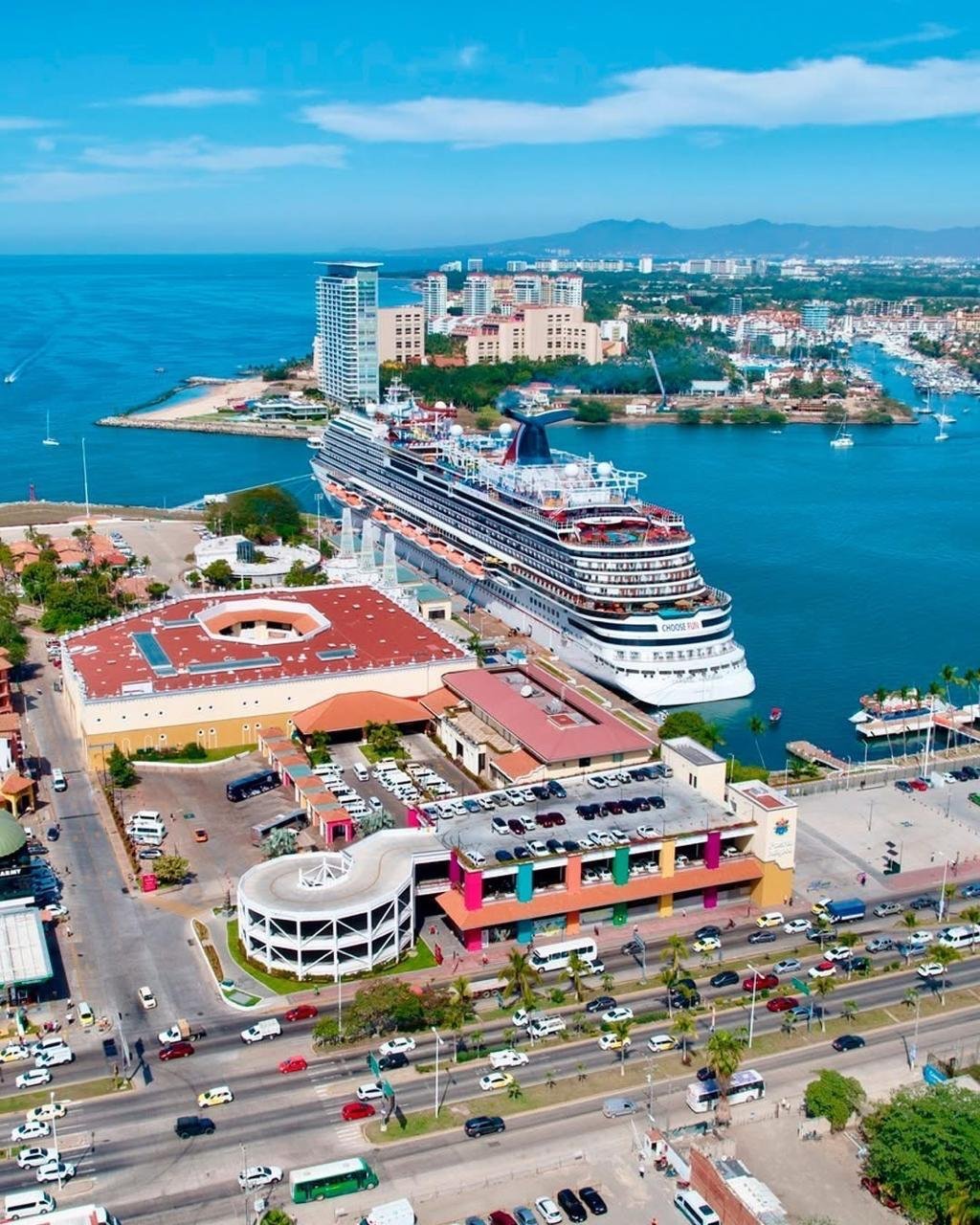 Aerial view of the Puerto Vallarta maritime terminal with a cruise ship docked beside the Puerto Mágico complex